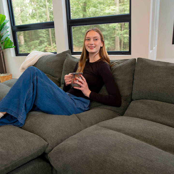 Woman having coffee on a sectional sofa 