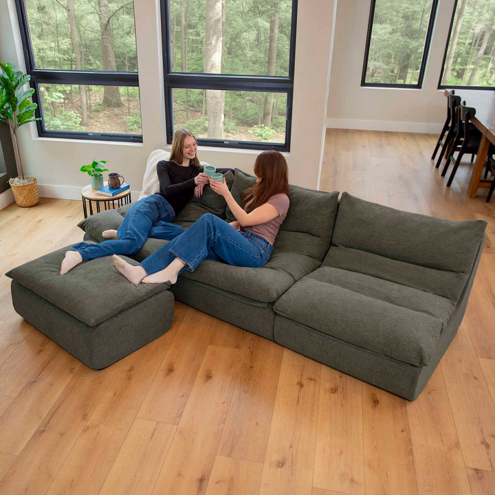 Woman relaxing on a pillow-top sofa in the living room Driftscape sectional sofa with ottoman fabric details 