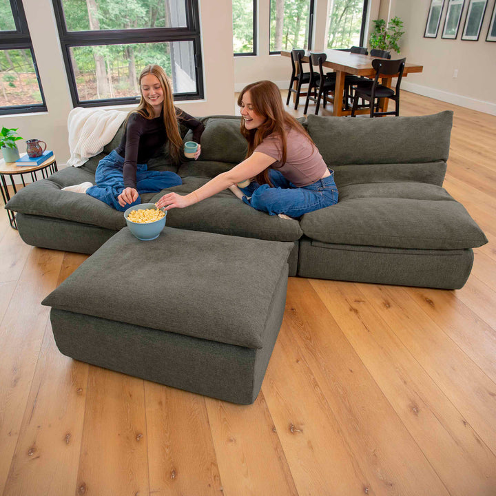 Two women eating popcorn on a Driftscape sectional sofa with ottoman 