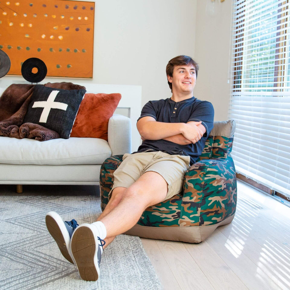 adult in bean bag chair with arm rests in camo 