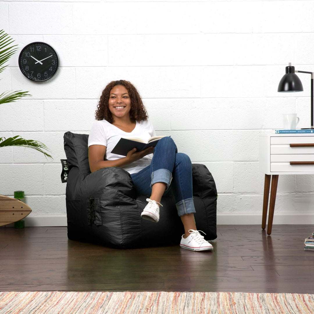 Woman reading on dorm beanbag chair in black #color_black-smartmax