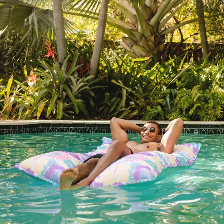 man on lagoon lounger floating in pool #color_aqua-tropical-hibiscus