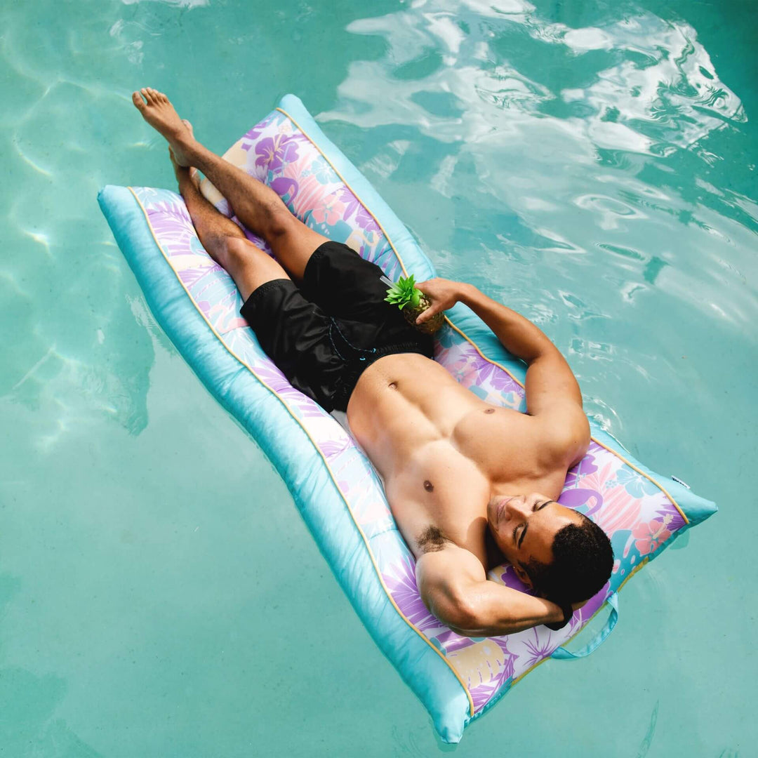 Man floating on kona pool lounger #color_aqua-tropical-hibiscus