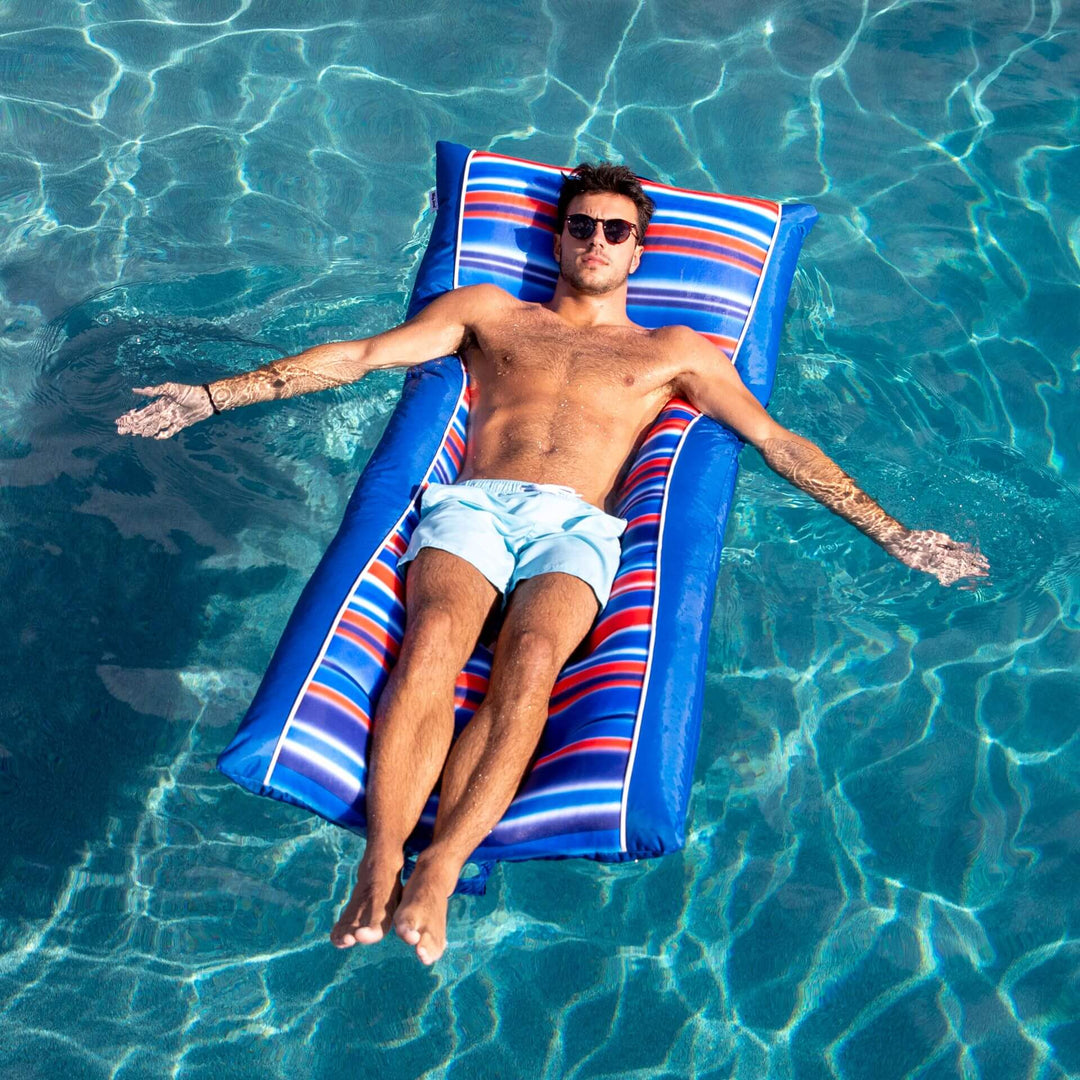 Man floating in pool on Kona lounger #color_blurred-americana