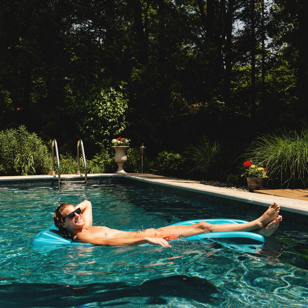 Man floating in pool on aquaria avena pool float lounge #color_aquaria-aqua
