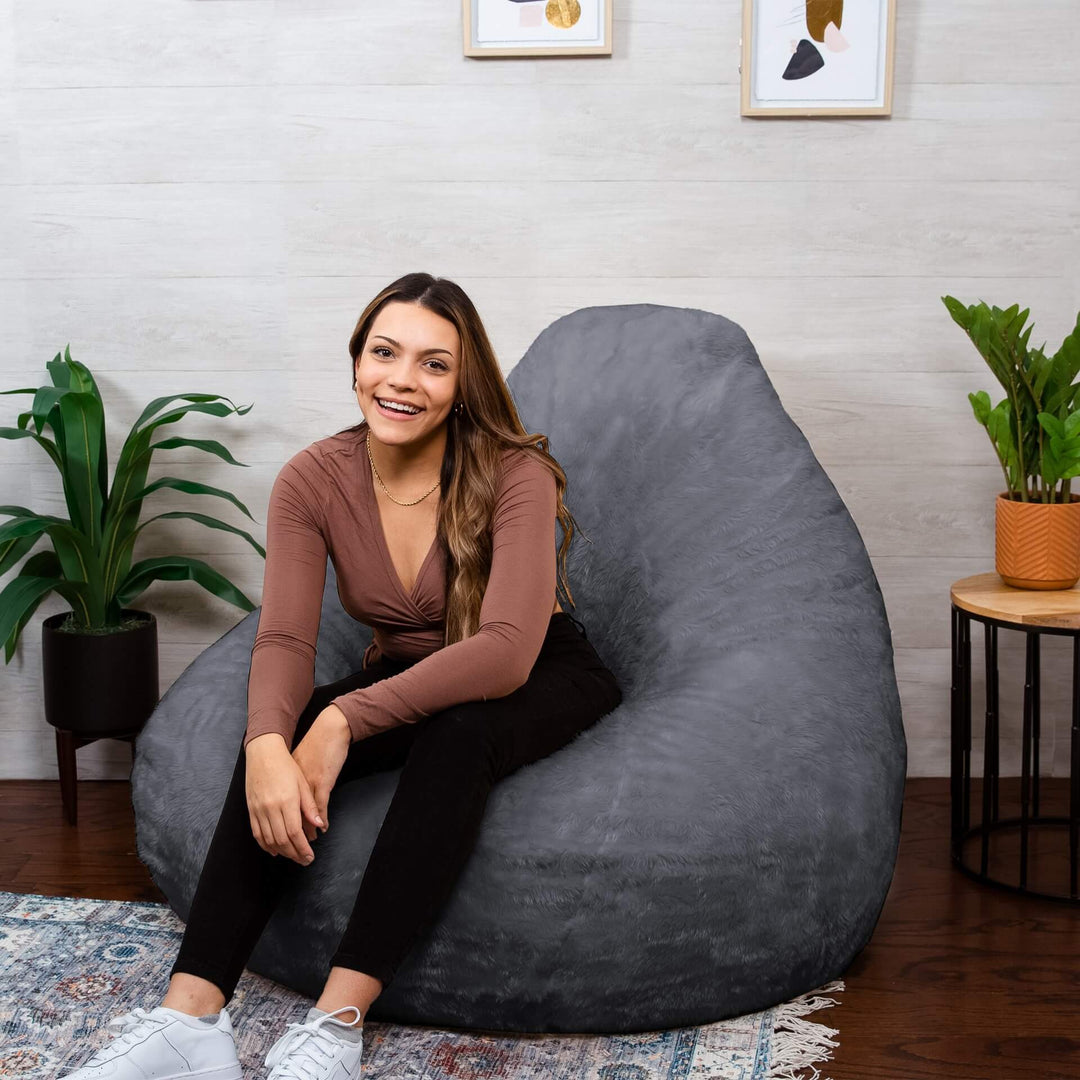 Woman on gray lotus foam filled beanbag chair #color_stone-short-shag