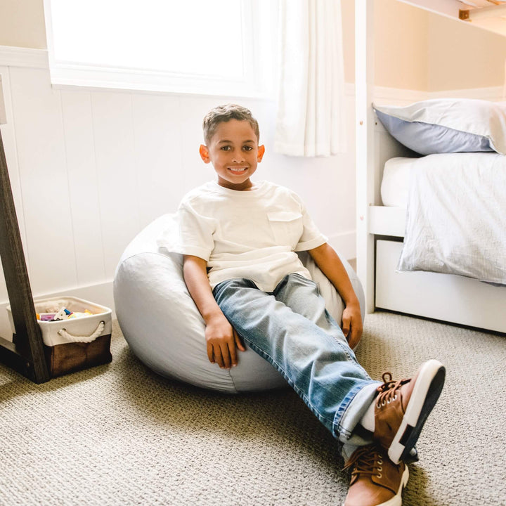 Gray beanbag chair with young boy relaxing #color_cloud-gray-gabardine
