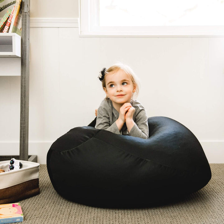 Girl on black beanbag chair for kids #color_peat-black-gabardine