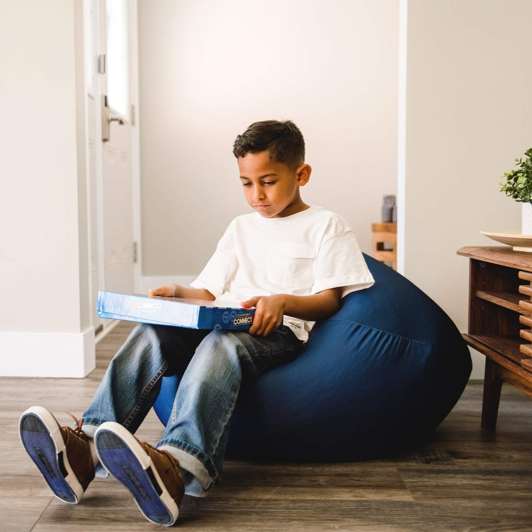 Blue beanbag chair with boy sitting playing games #color_true-navy-gabardine
